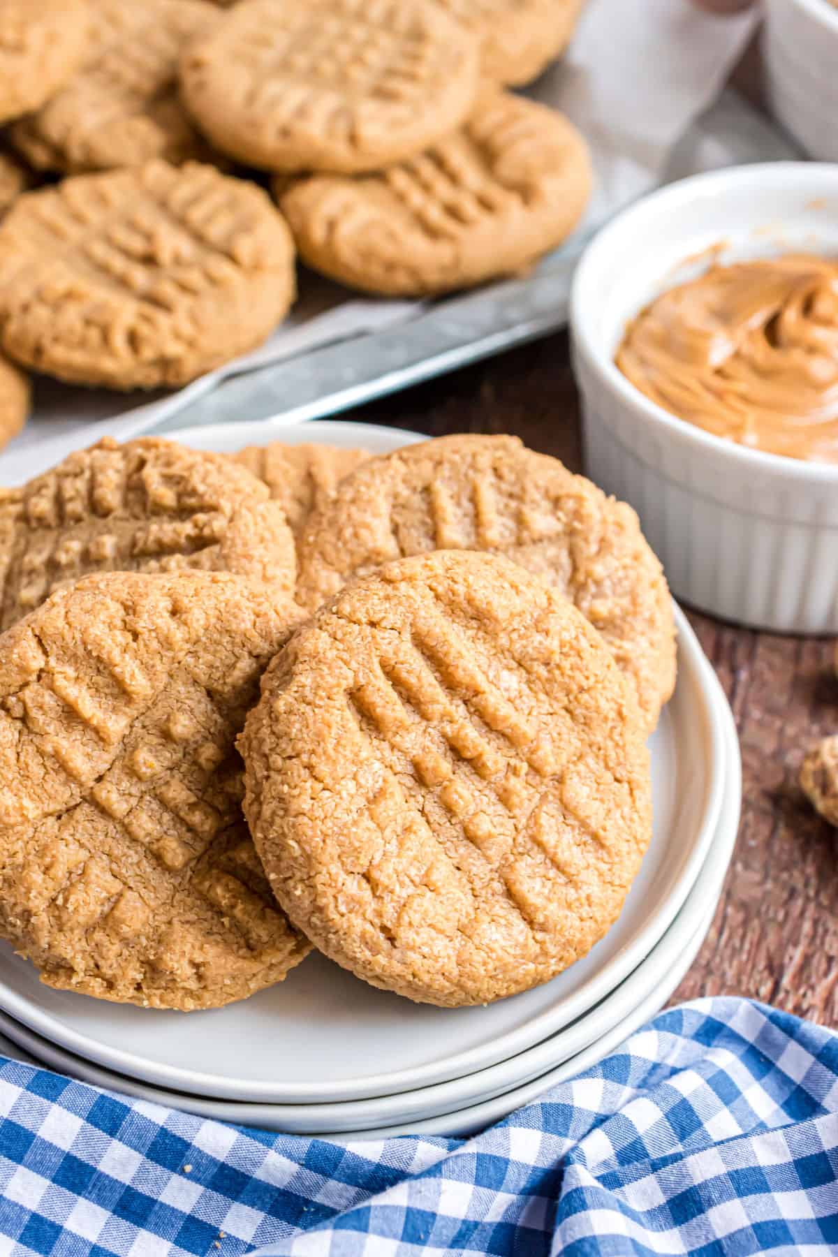 Peanut butter cookies stacked on a white dessert plate.