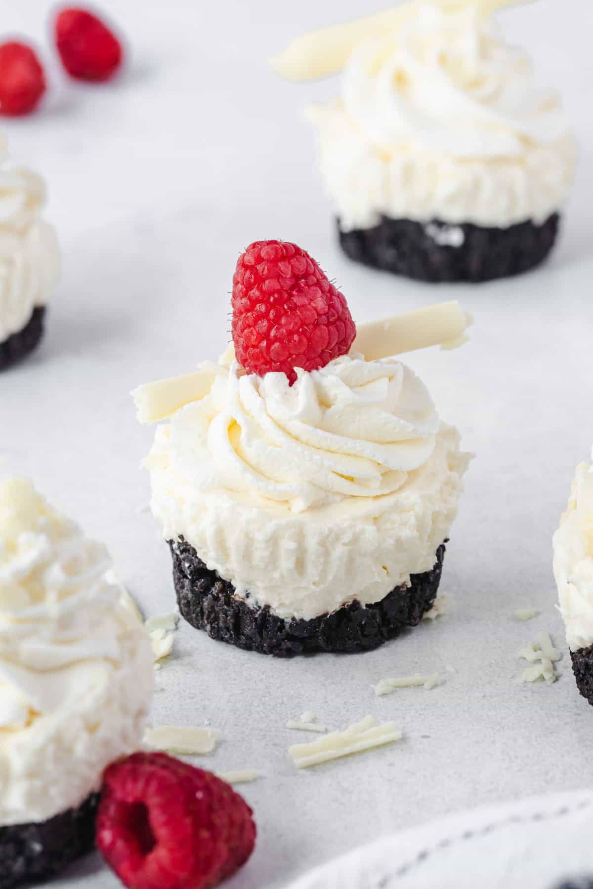 Mini cheesecake with oreo crust and a raspberry on top.