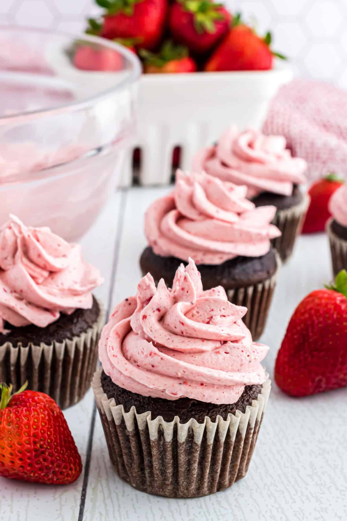 Strawberry frosting swirled on top of chocolate cupcakes.