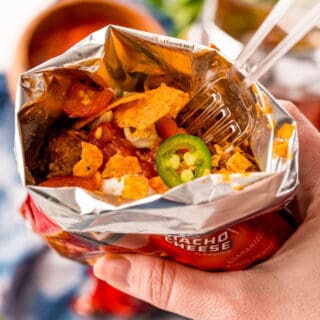 Make the famous fair food at home! This Walking Tacos recipe is a quick and easy meal you can eat on the go. Seasoned beef is mixed into bags of Doritos and topped with your favorite taco fixings!