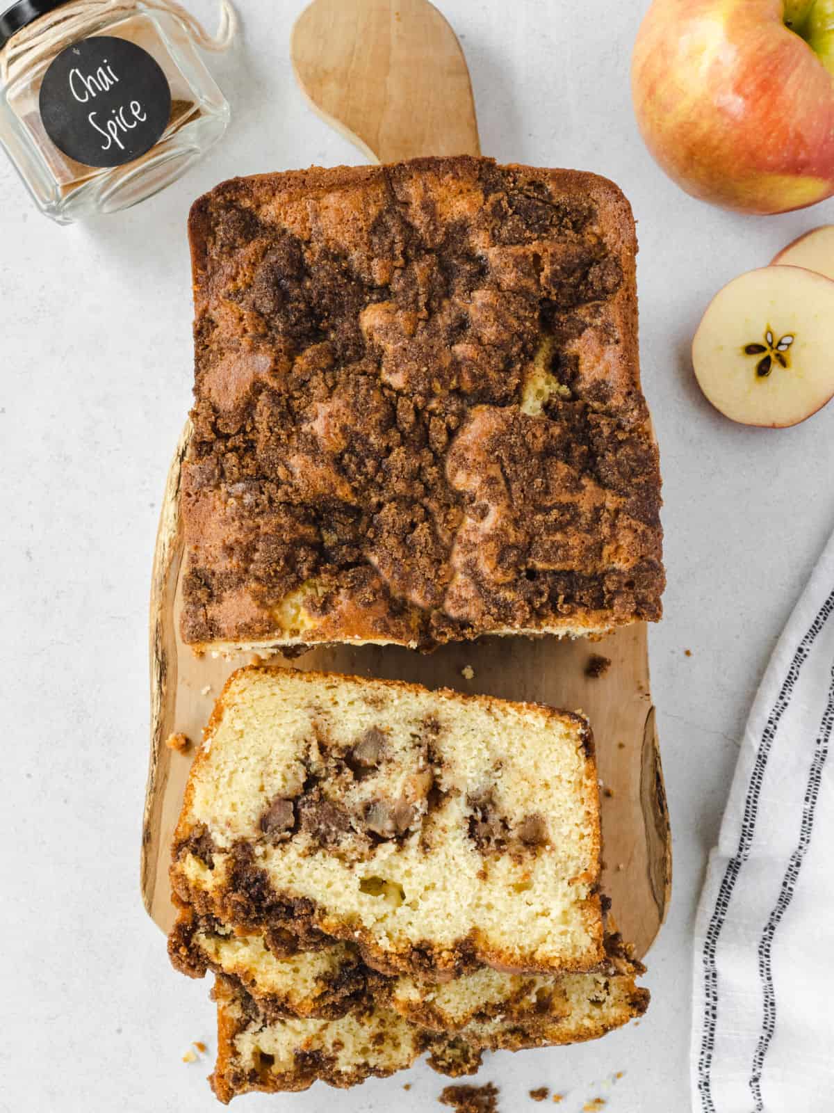 Loaf of apple chai bread sliced on cutting board.