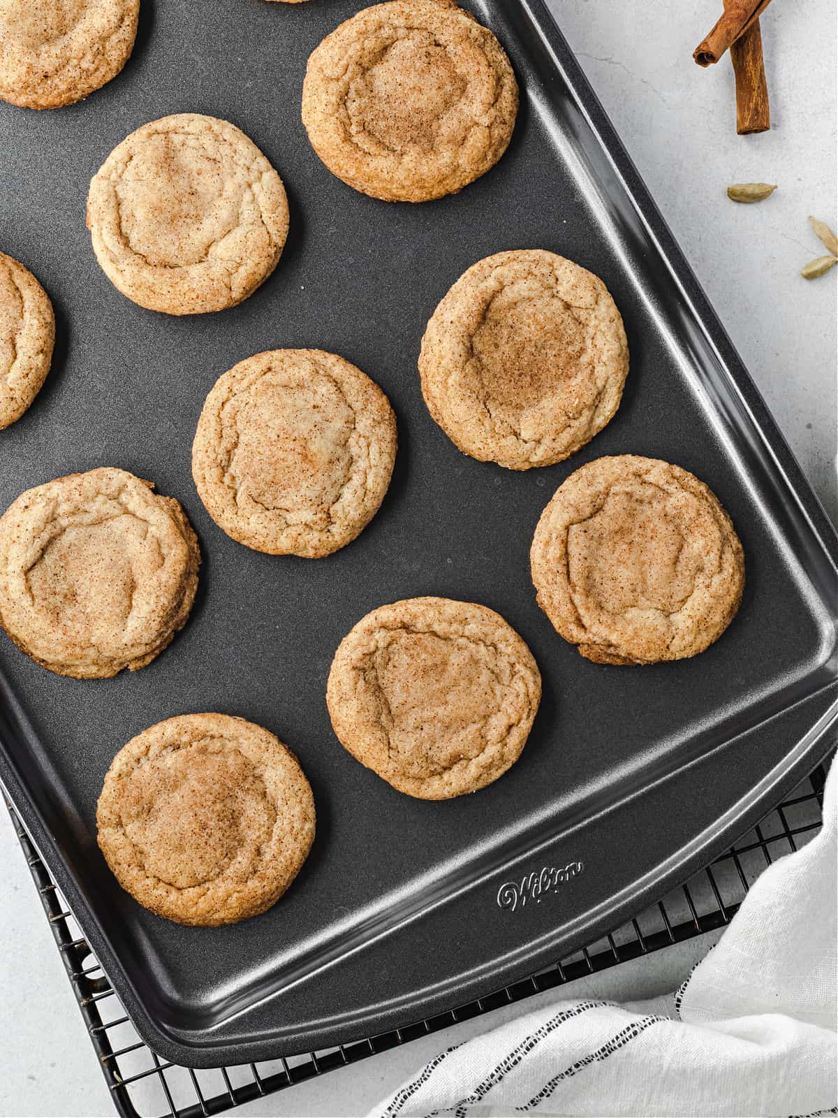 Chai spice cookies on a baking sheet cooling.