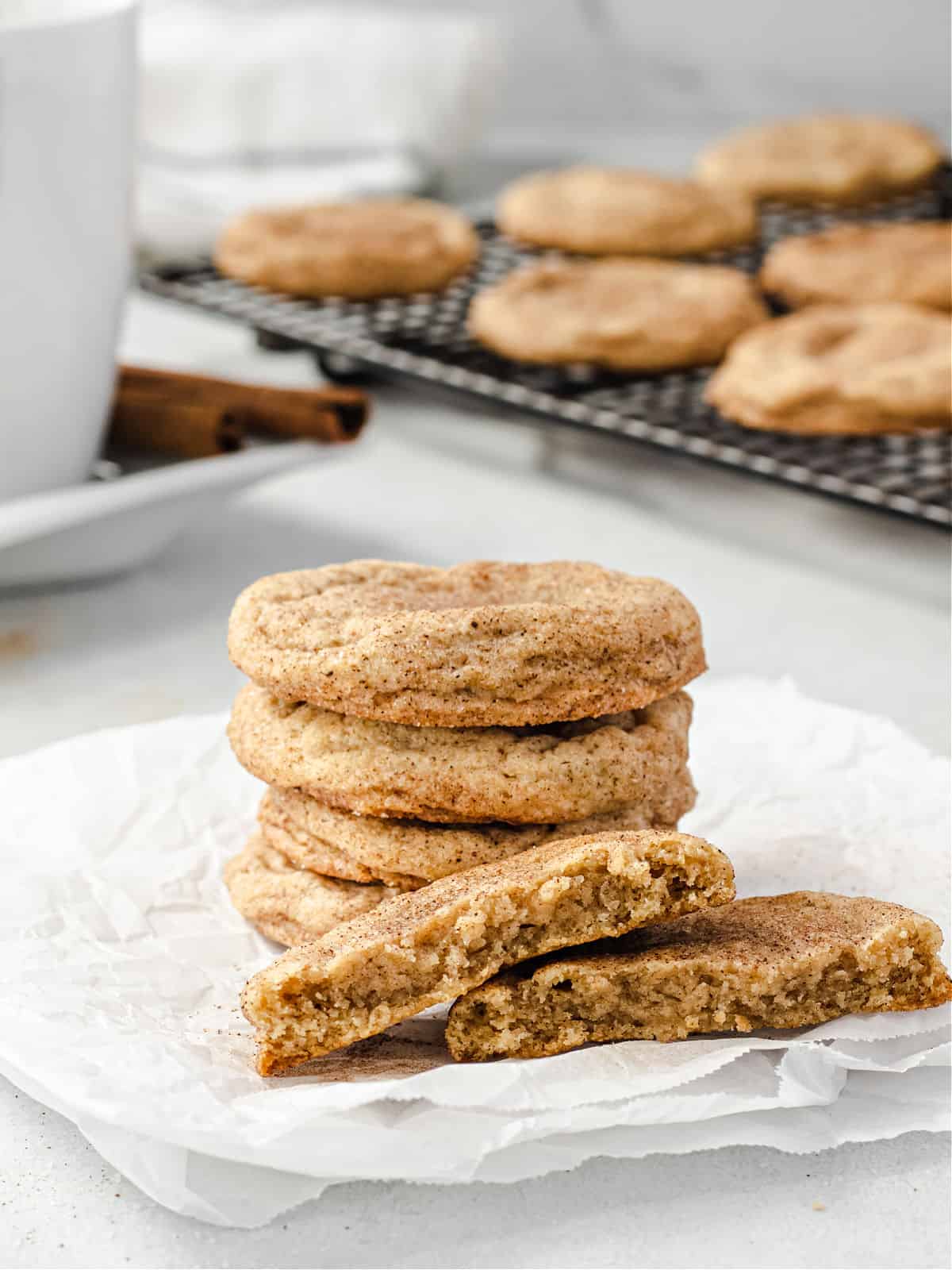 Stack of chai cookies with one broken in half showing chewy texture.