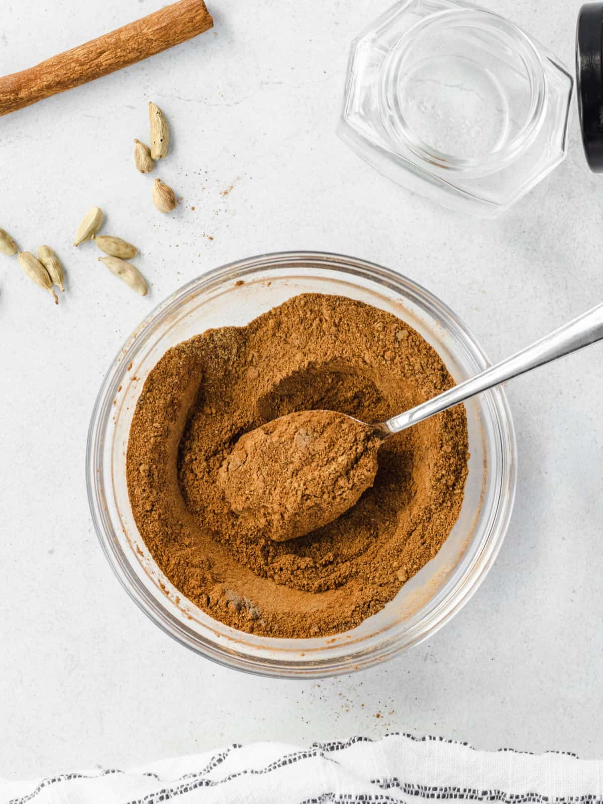 Chai spice mix blended in a bowl with a spoon.