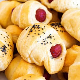 Pigs in a blanket sprinkled with poppy seeds.