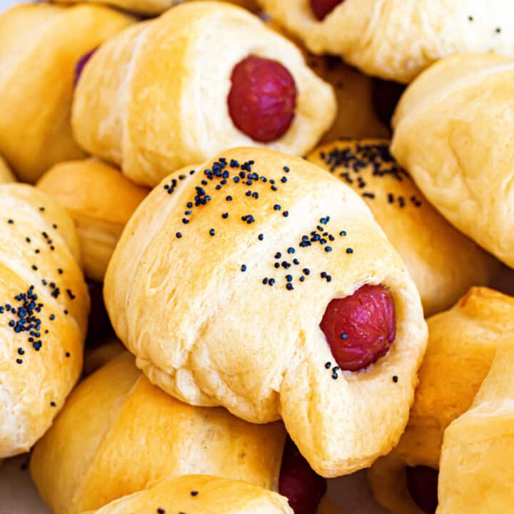 Pigs in a blanket sprinkled with poppy seeds.