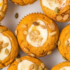 Pumpkin Cream Cheese Muffins are a copycat Starbucks treat. Packed with flavor, these muffins have a sweet cream cheese filling and spiced pumpkin seeds sprinkled on top. Easy to make and freezer friendly!