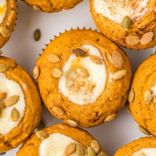 Pumpkin Cream Cheese Muffins are a copycat Starbucks treat. Packed with flavor, these muffins have a sweet cream cheese filling and spiced pumpkin seeds sprinkled on top. Easy to make and freezer friendly!