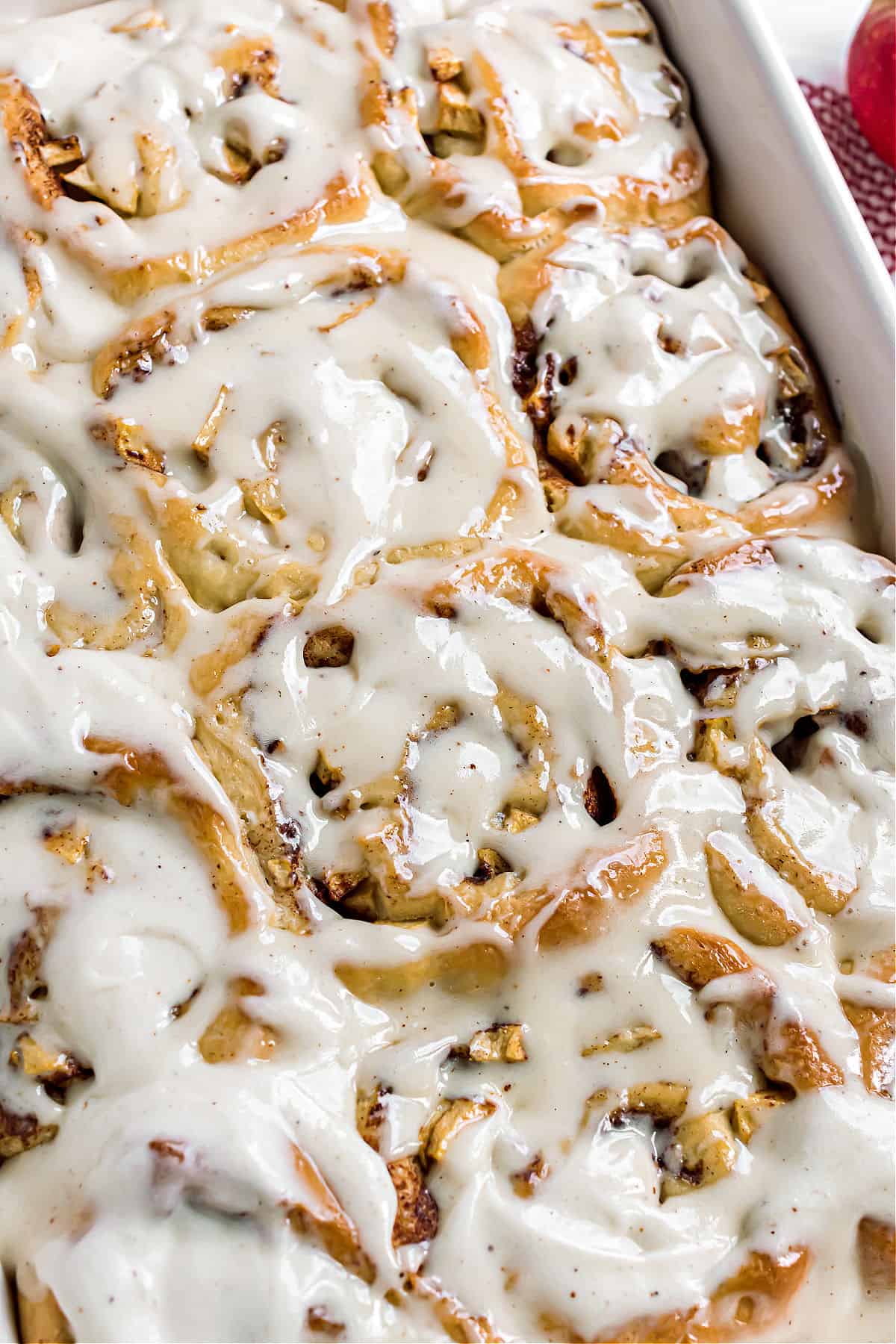 Baking dish with iced apple cinnamon rolls.