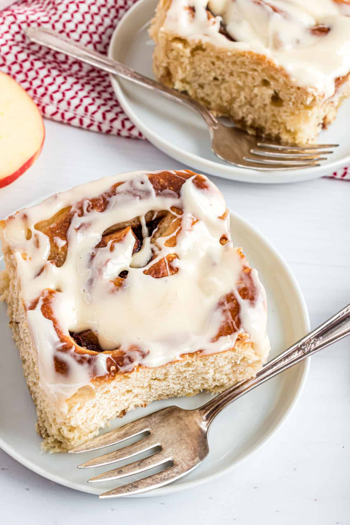 Apple cinnamon rolls served on small white dessert plates.