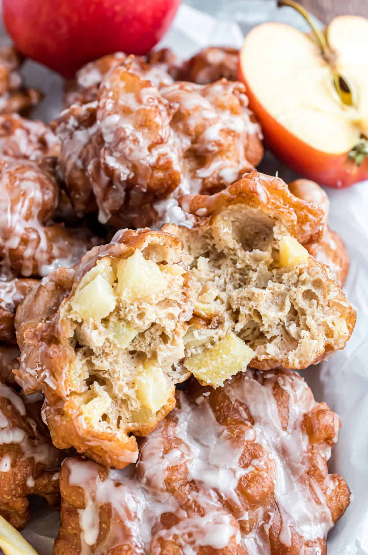 Stack of apple fritters with one bit removed to show inside.