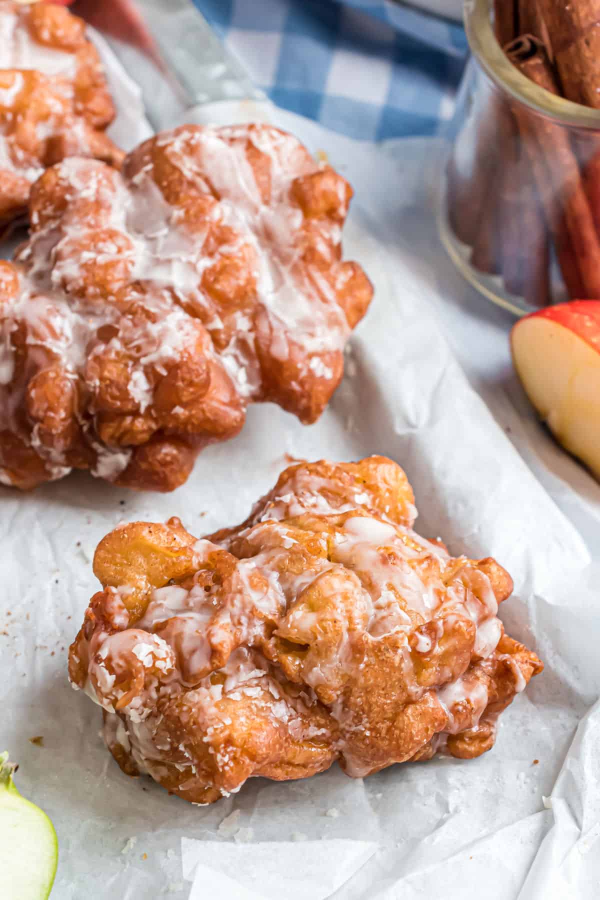 Fried apple fritters on parchment paper.