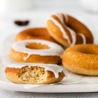 White plate with chai donuts, one bite removed.