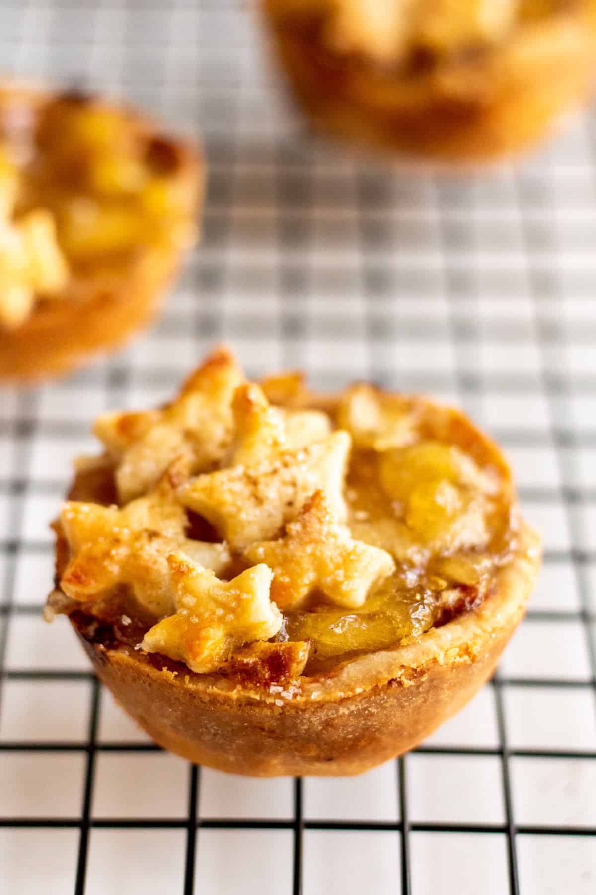 Mini apple pies on a wire cooling rack.