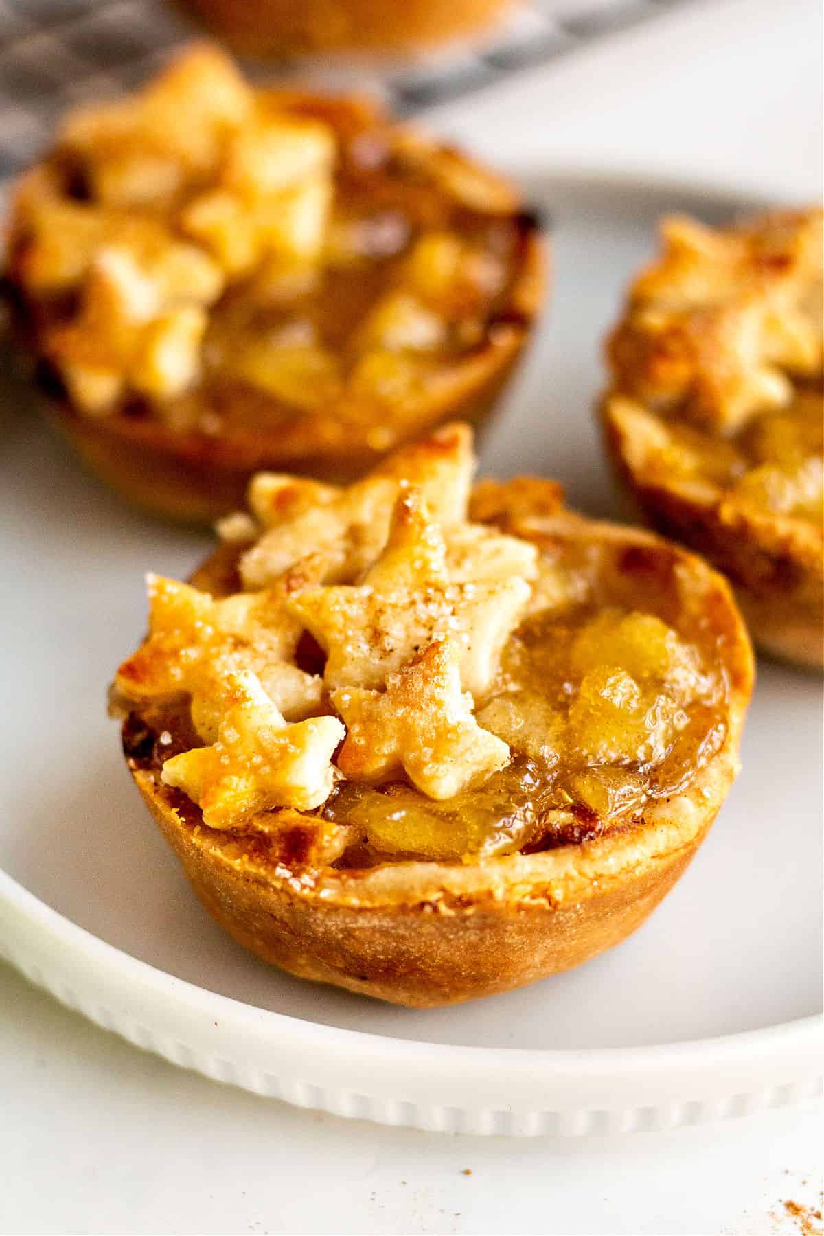 Mini apple pies on a white dessert plate.