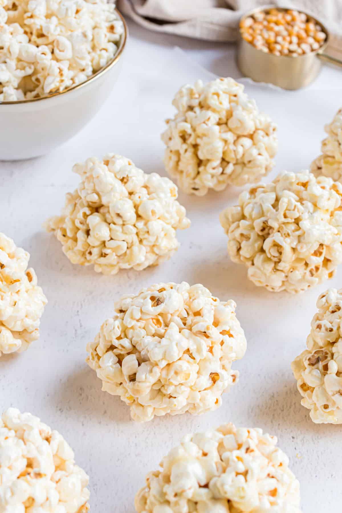 Popcorn balls shaped on a piece of parchment paper.