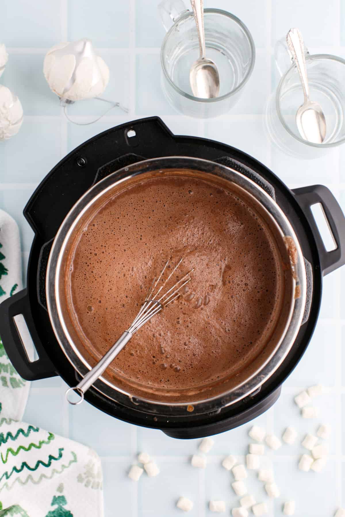 Creamy hot chocolate in the Instant Pot with a ladle.
