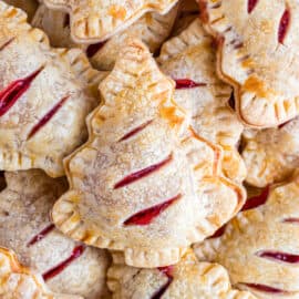 Christmas tree shaped cherry hand pies stacked on a plate.