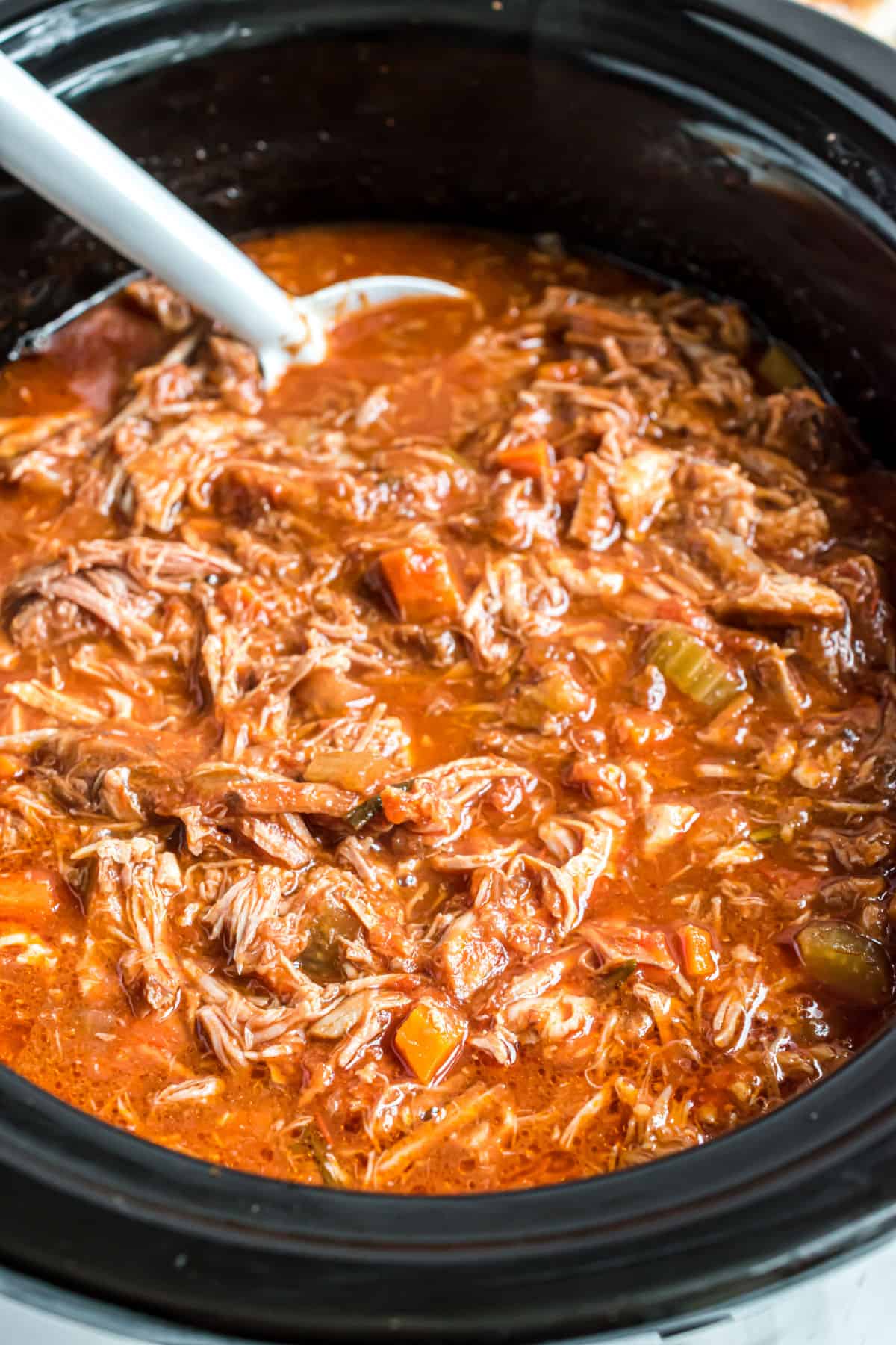 Pork ragu sauce in black slow cooker.