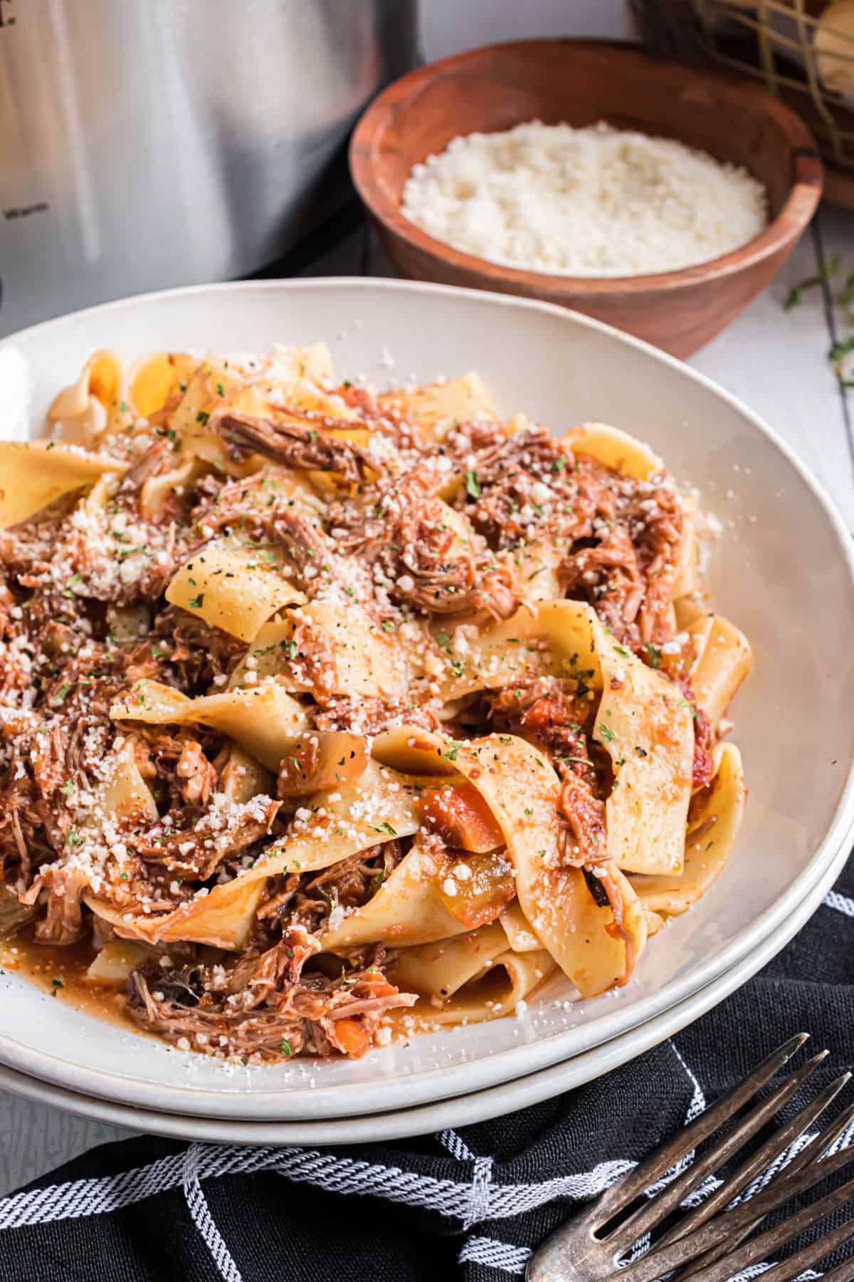 Pork ragu on pappardelle pasta with grated parmesan cheese.