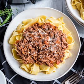 Italian flavors shine in this slow cooker Pork Ragu recipe. Cooked for hours in the crockpot in an herb infused wine sauce, the juicy, shredded pork is served over pappardelle pasta for an irresistible Italian dinner.