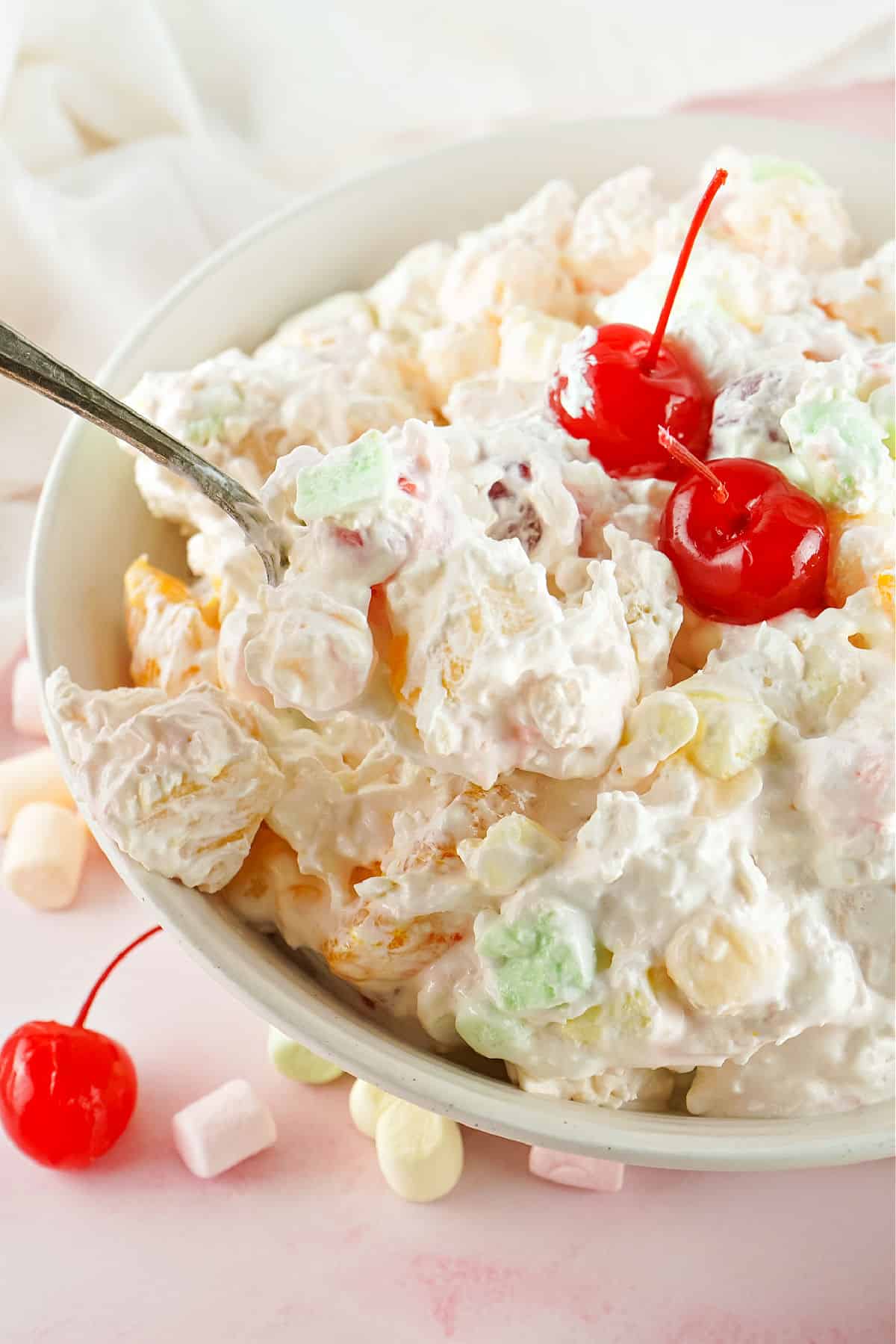 Ambrosia salad in a bowl with spoon for serving.