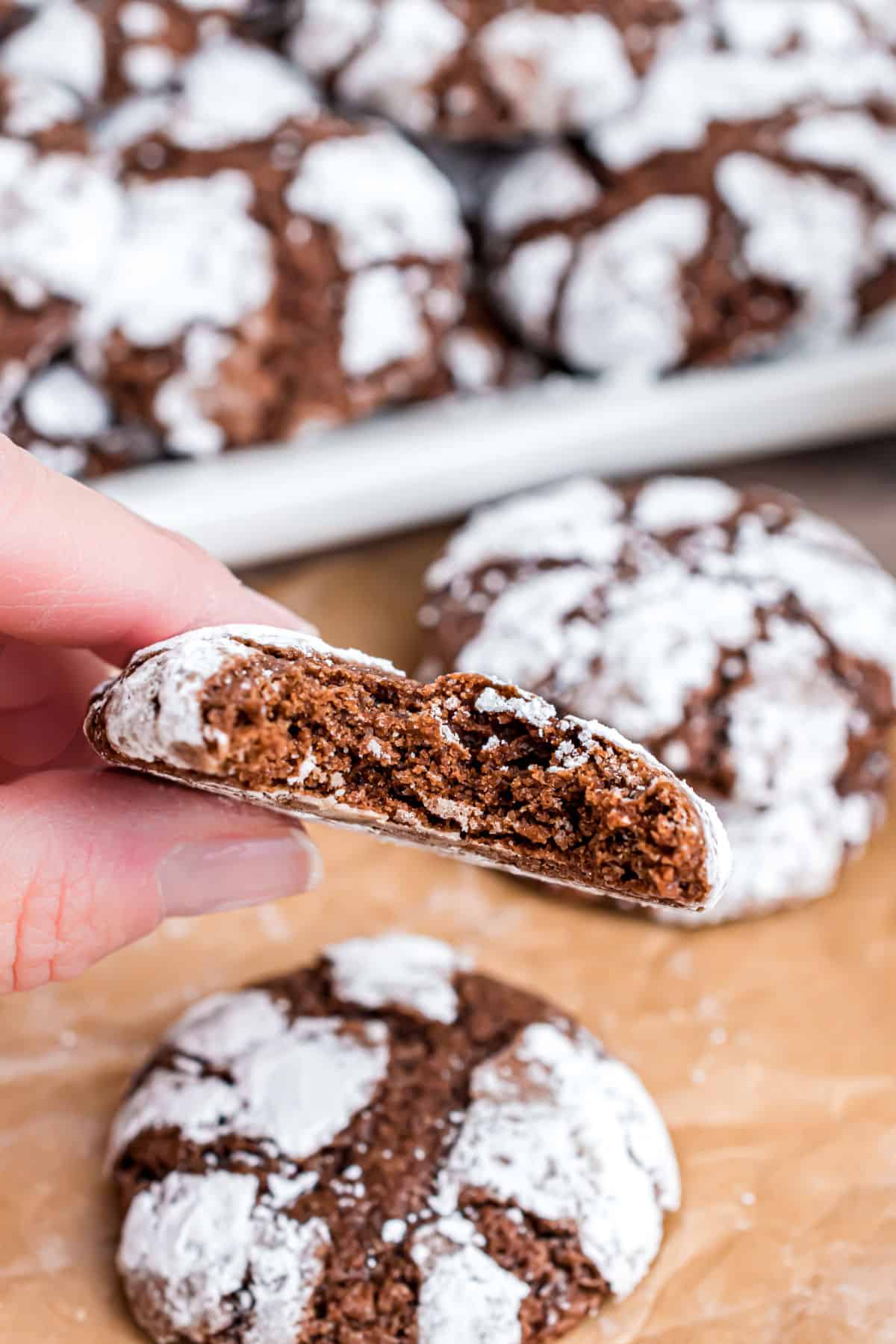 Chocolate crinkle cookies with a bite taken.