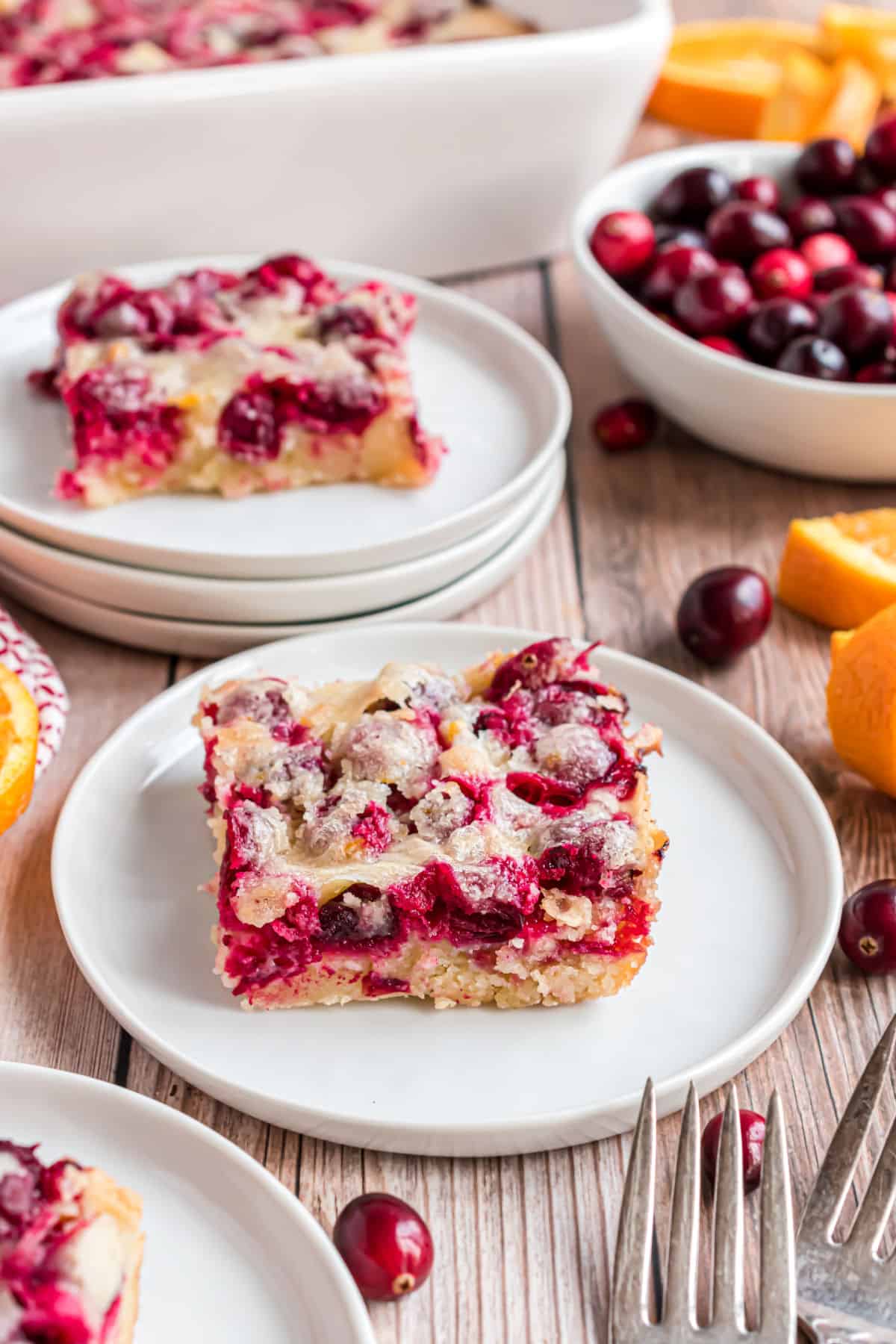 Slices of cranberry breakfast cake on white plates.