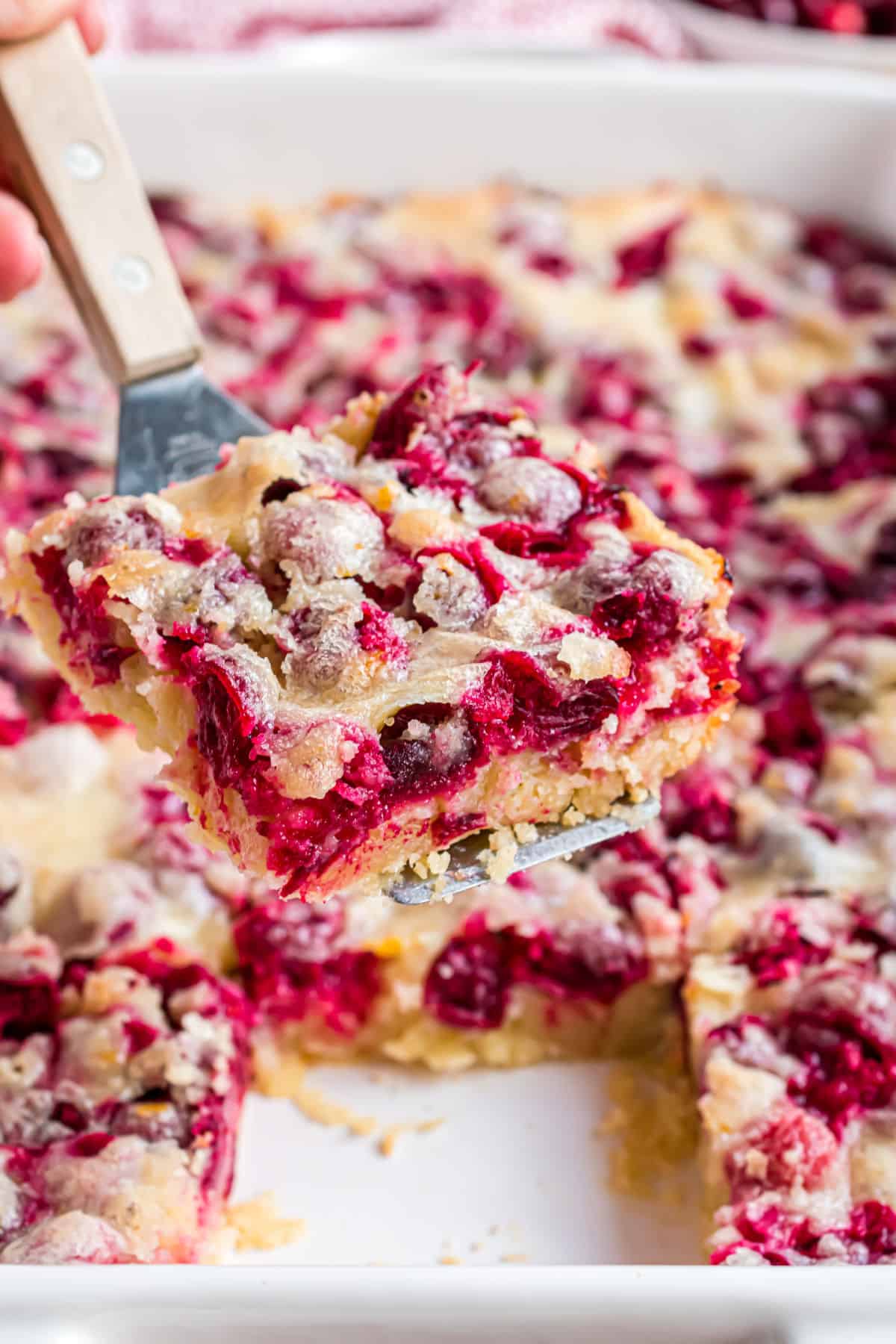 Cranberry cake served with a spatula.