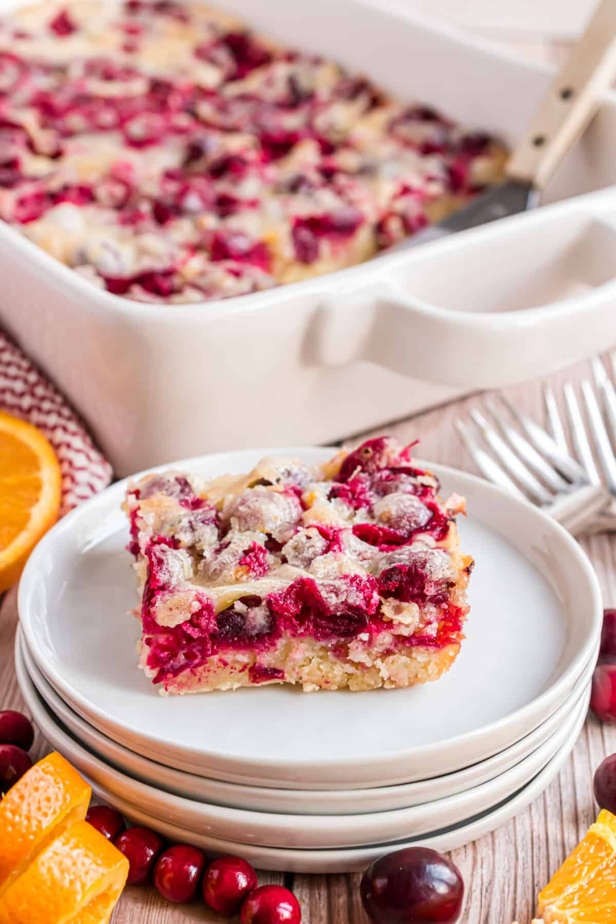 Cranberry Christmas cake served on a stack of white plates.