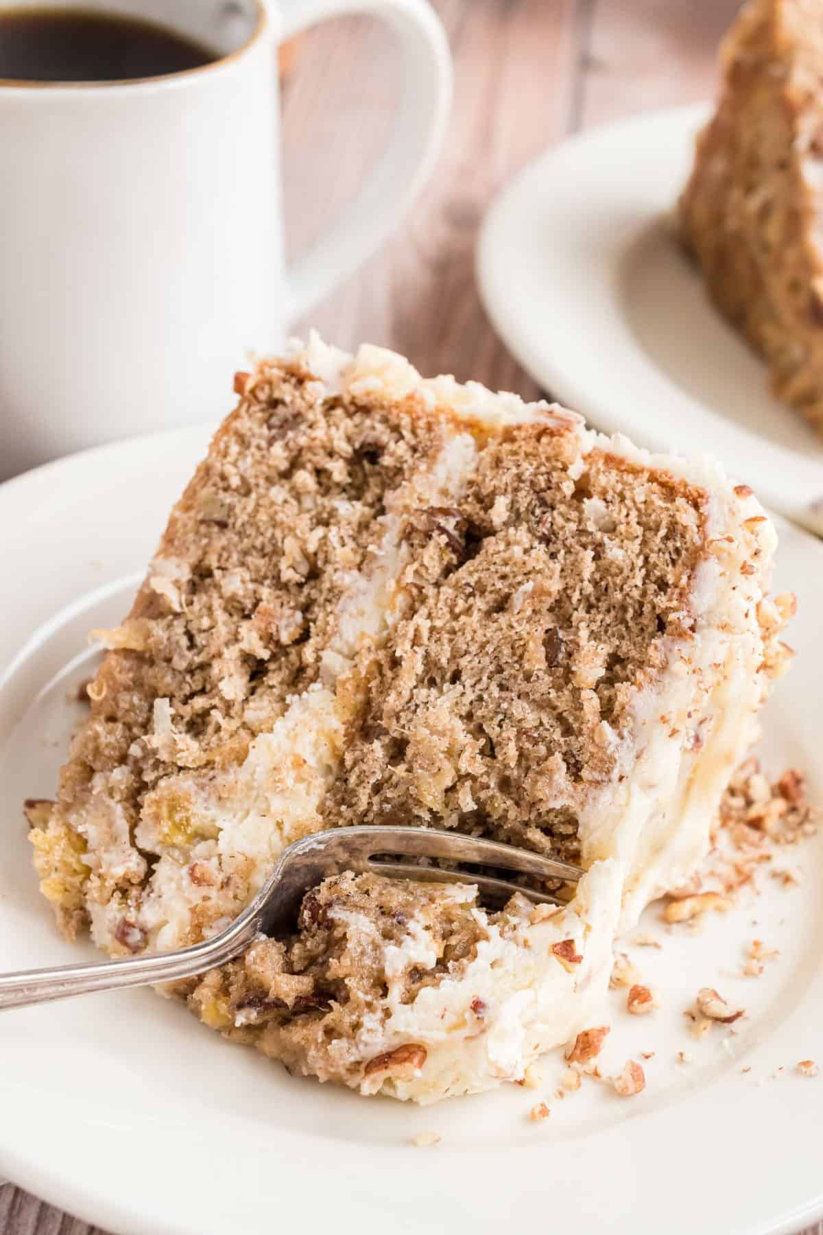 Slice of hummingbird cake with a fork taking a bite.