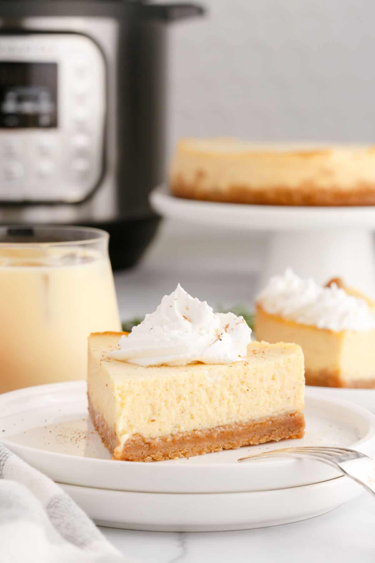 Slices of eggnog cheesecake made in the Instant Pot and served on white plates.