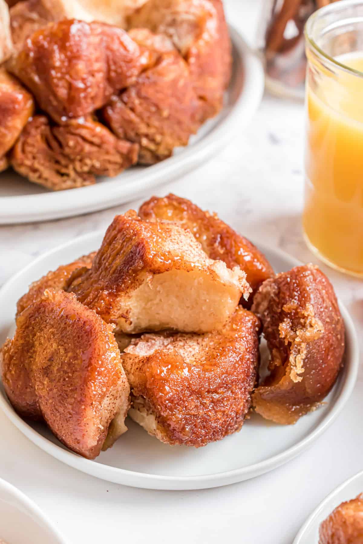 Monkey bread on a white plate with orange juice.