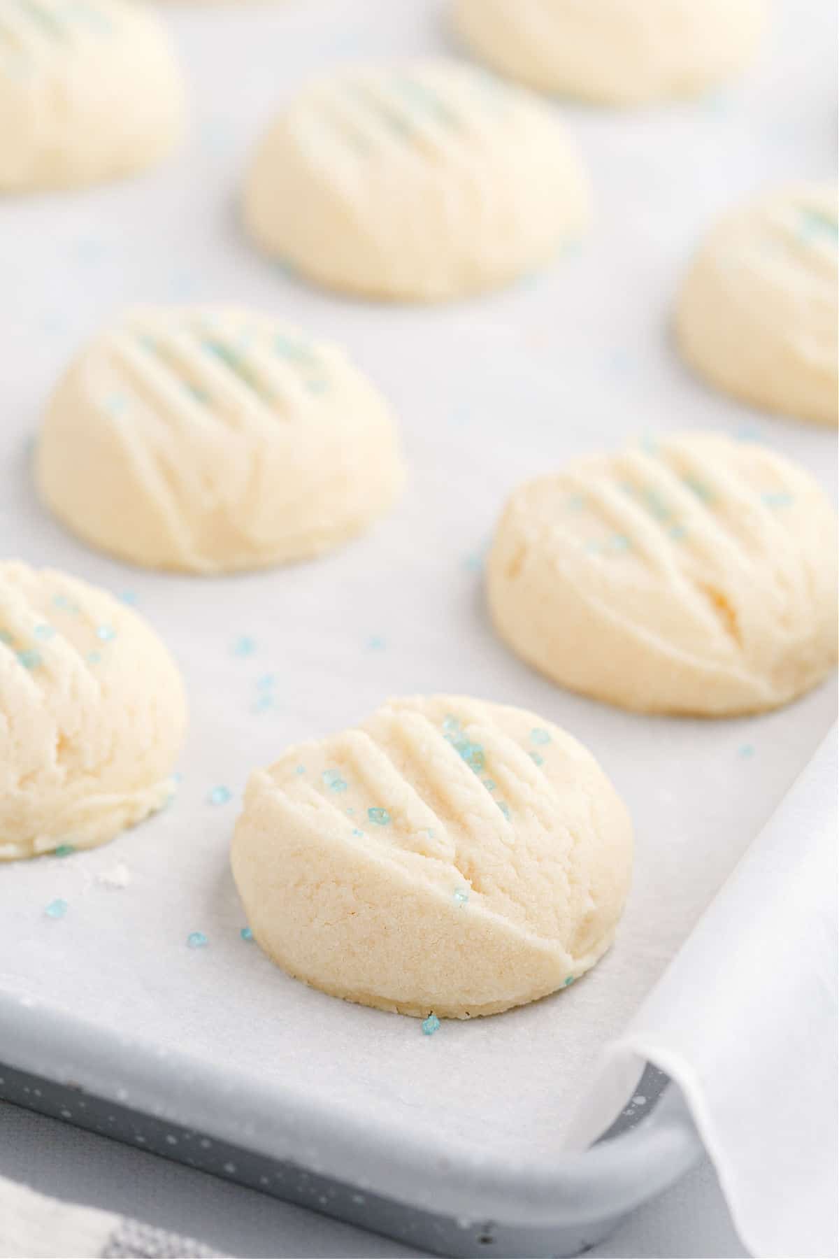 Shortbread cookies baked on a parchment paper lined cookie sheet.