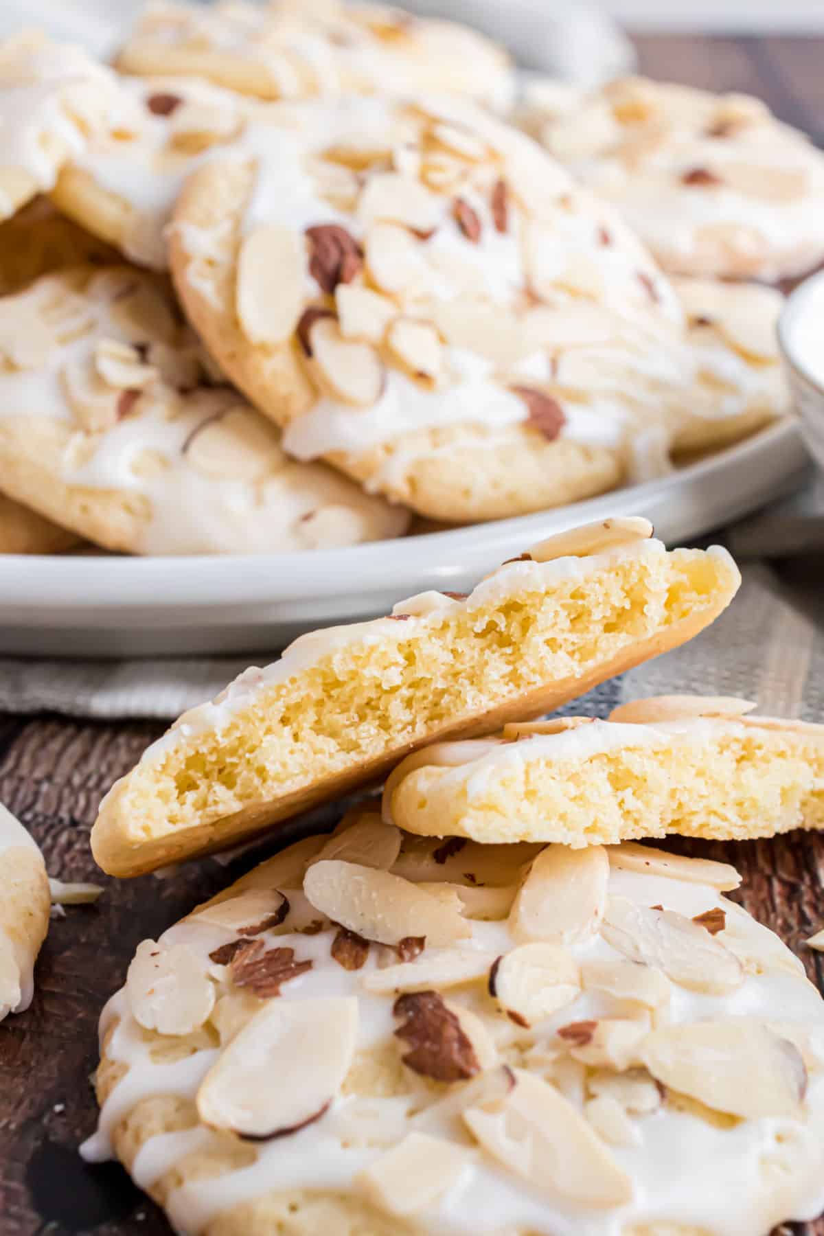 Almond cookies stacked with one broken in half.