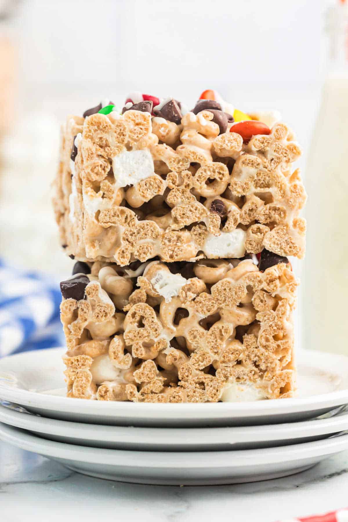 A stack of two cheerio bars on a stack of white plates.