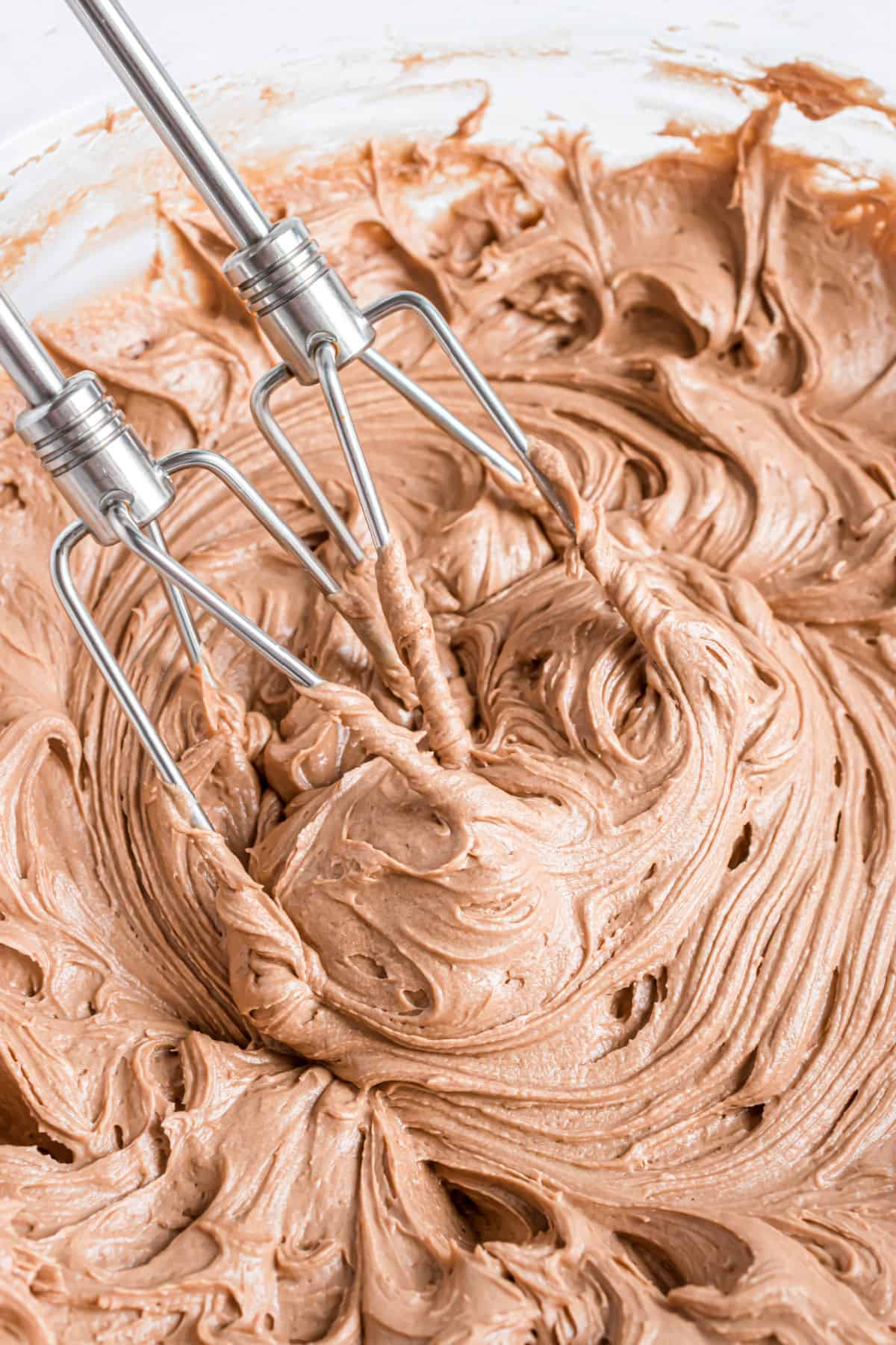 Chocolate cream cheese frosting in a clear glass bowl.