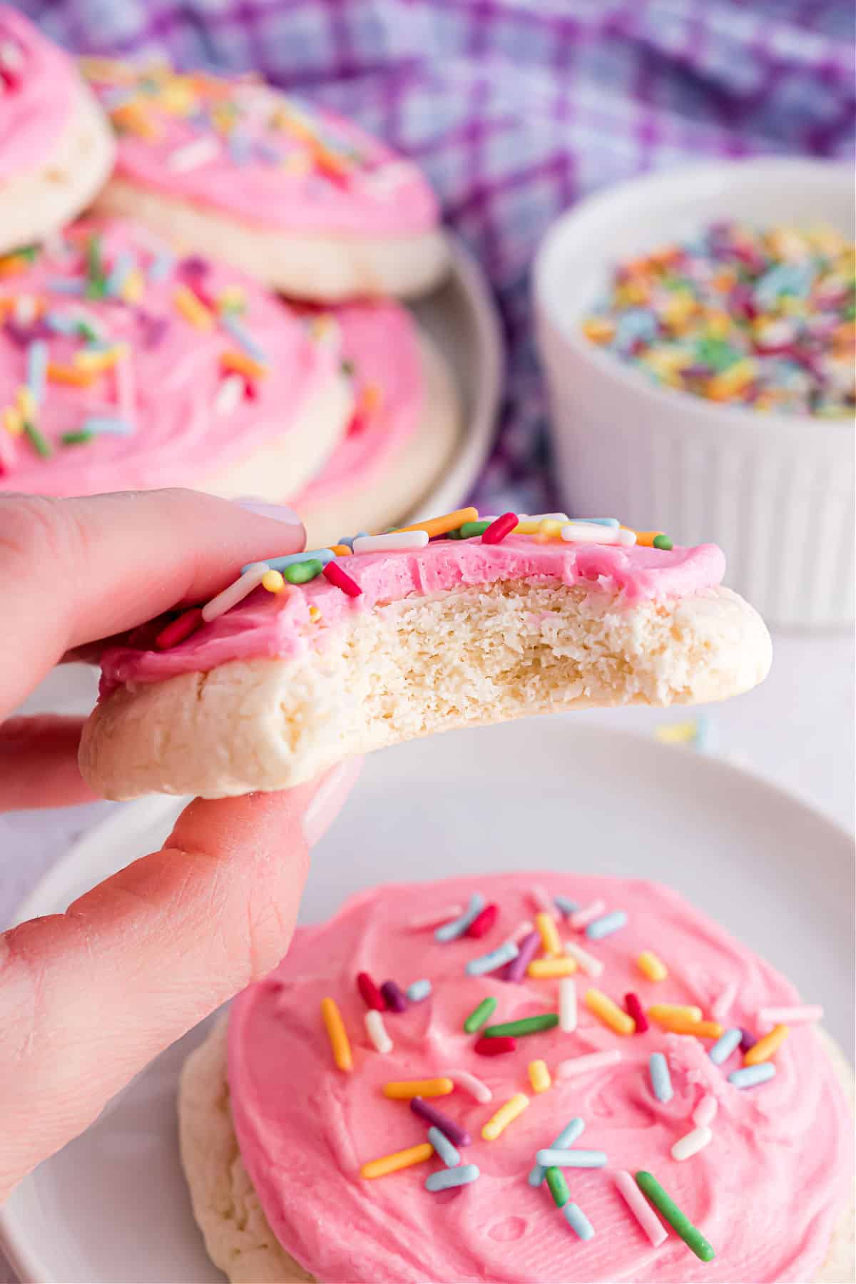 Cookie with pink frosting and bite taken out.