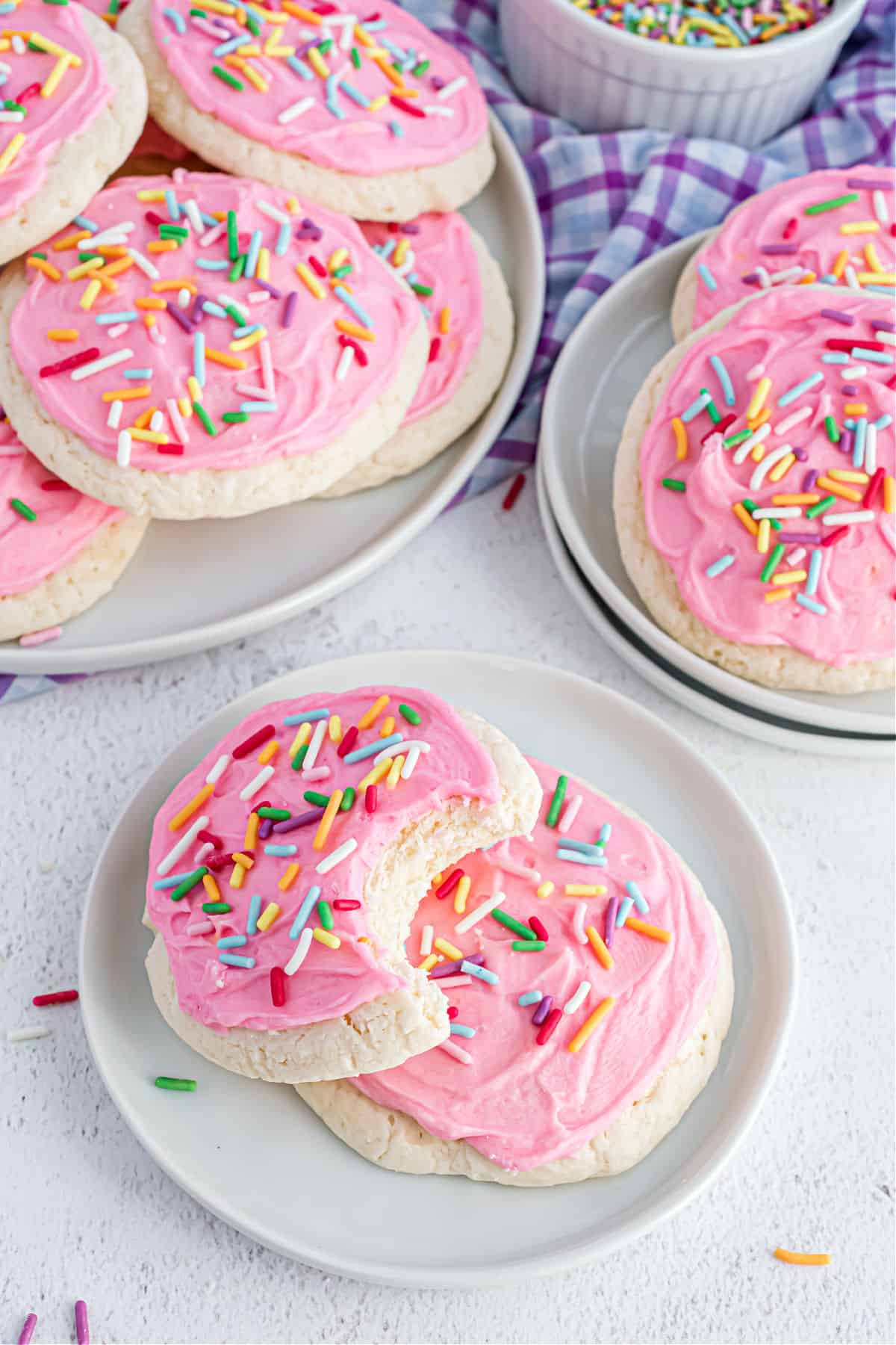 Cookies with pink frosting on a white plate.