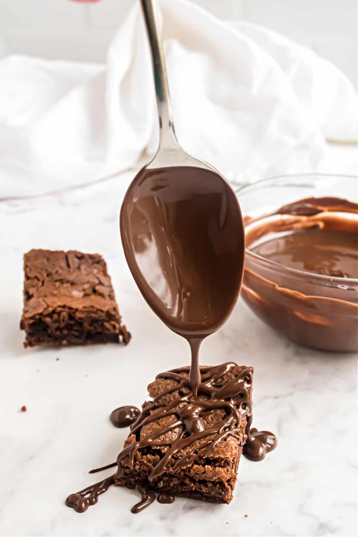 Brownie bites being drizzled with melted chocolate.