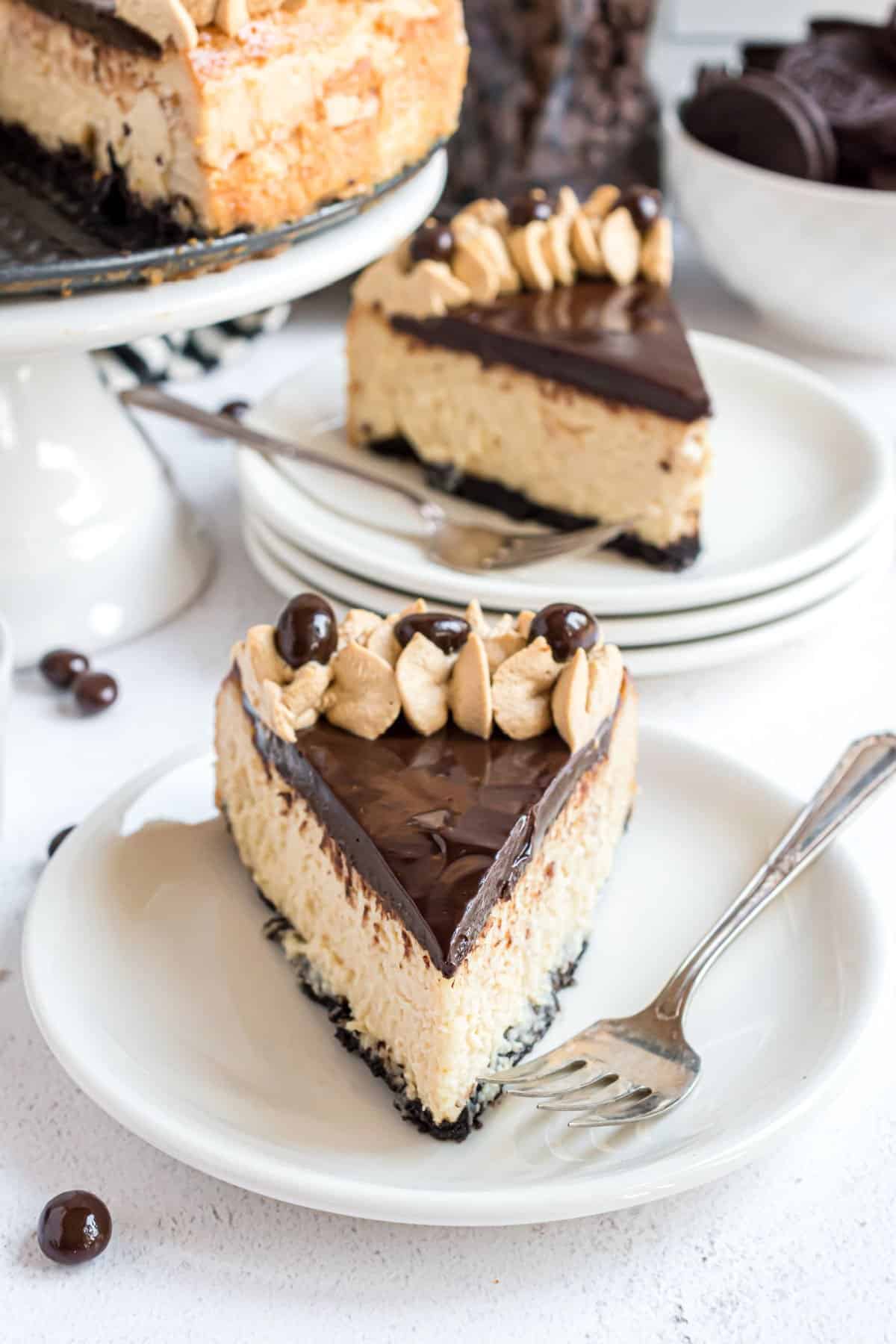 Slice of Baileys cheesecake with chocolate ganache on a white plate.