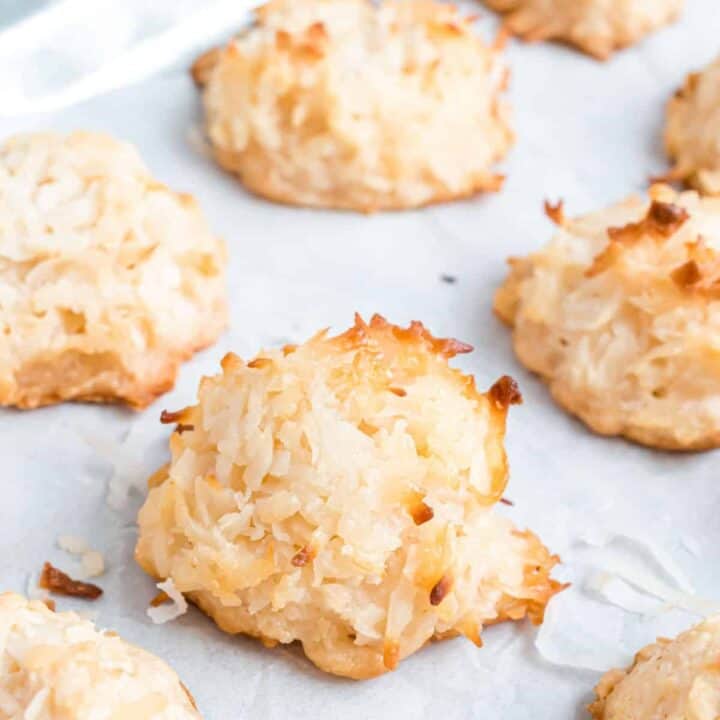 Coconut macaroons on parchment paper lined baking sheet.