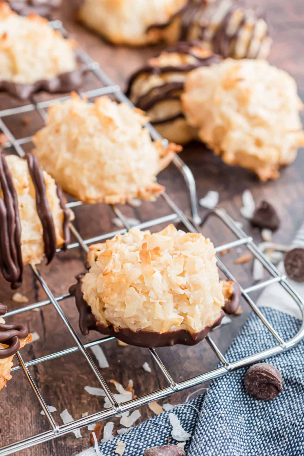 Coconut macaroons on a wire cooling rack, some dipped in chocolate.