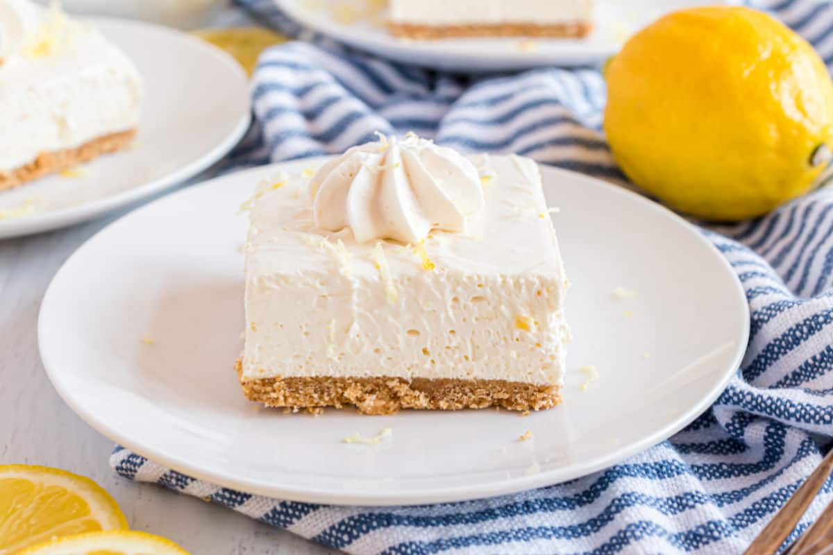Square slice of lemon cheesecake with lemon zest.