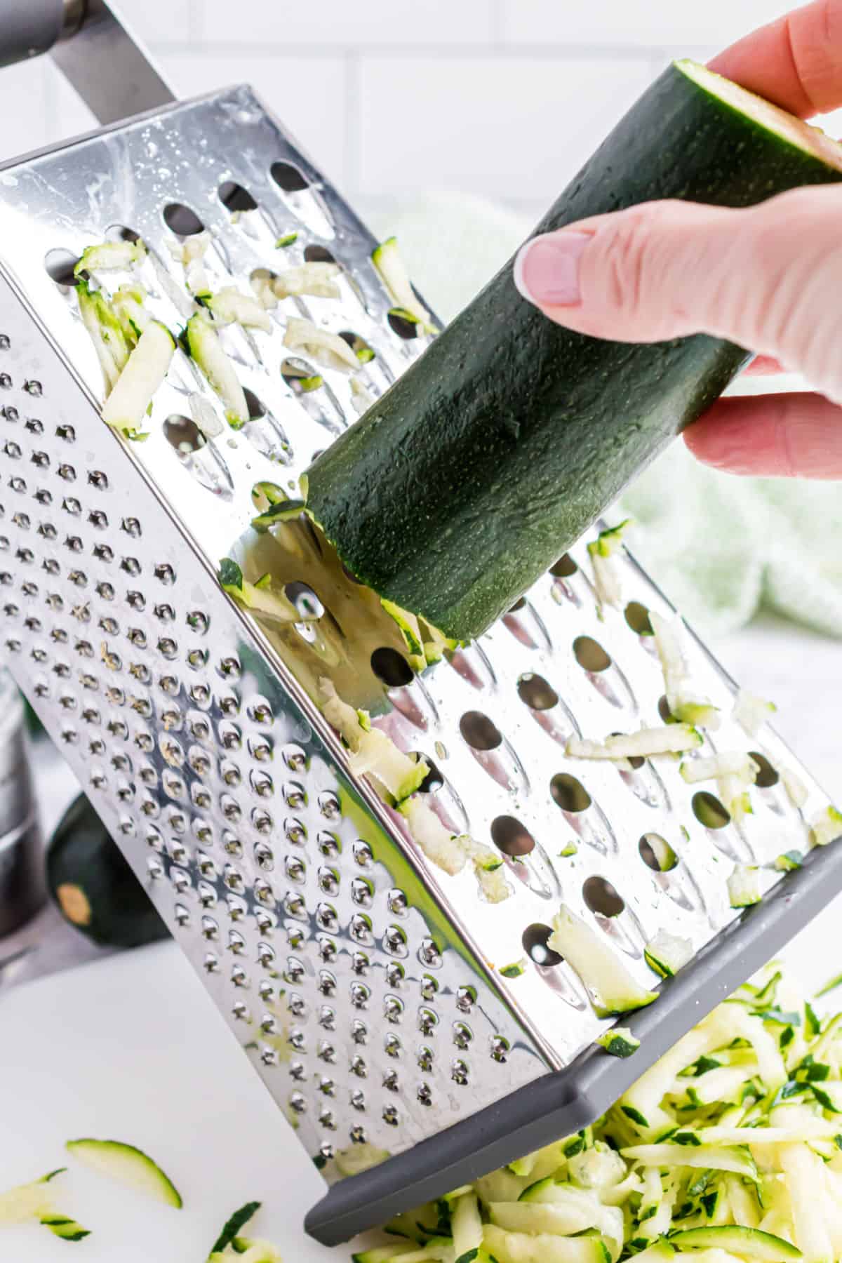 Shredding a zucchini with a box grater.