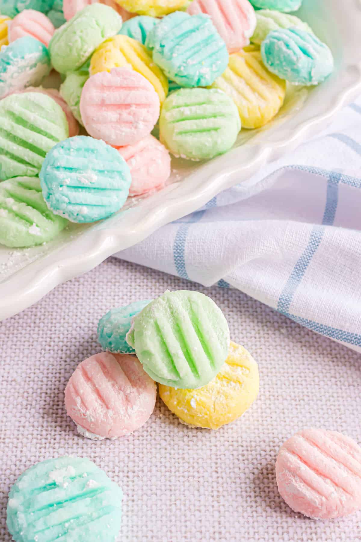Cream cheese mints in pastel colors stacked on each other.