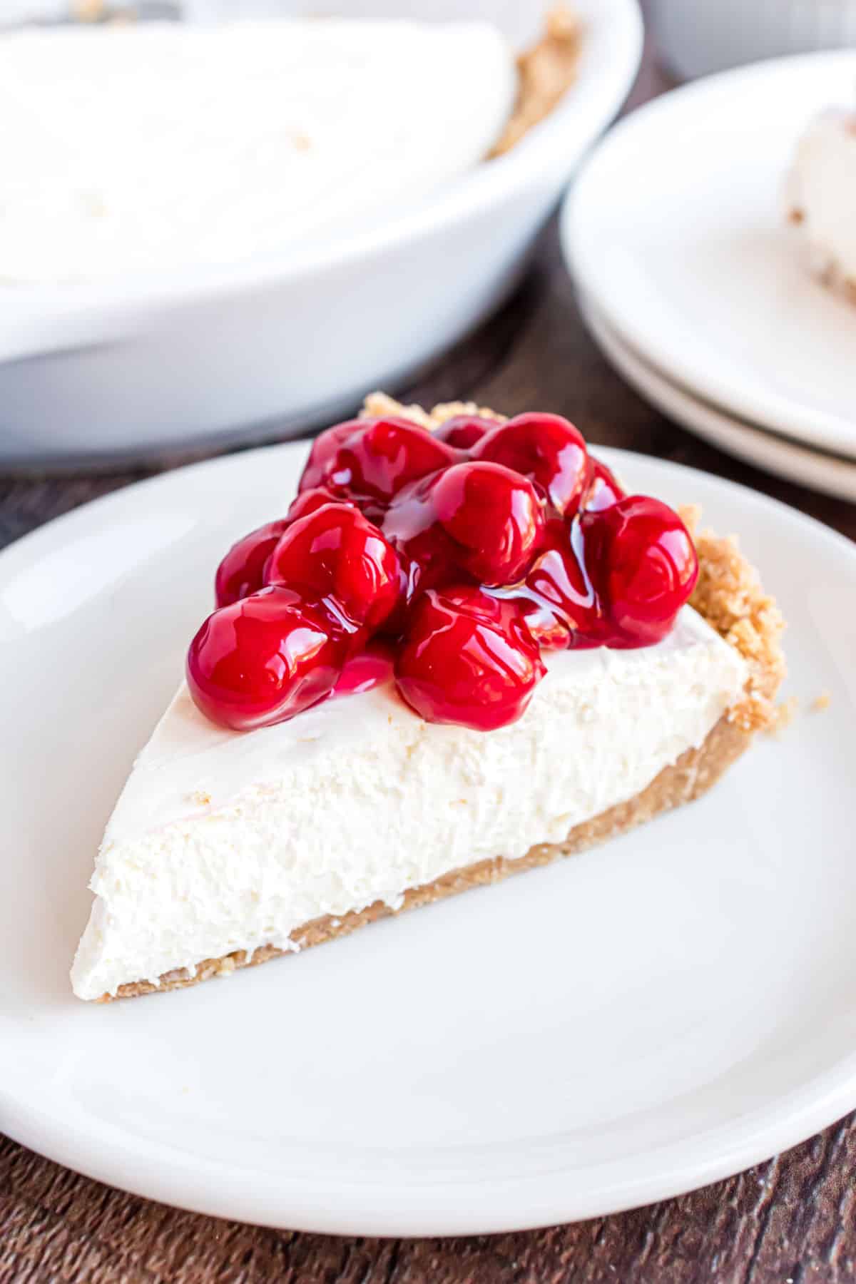 Slice of cheesecake with cherry pie filling.