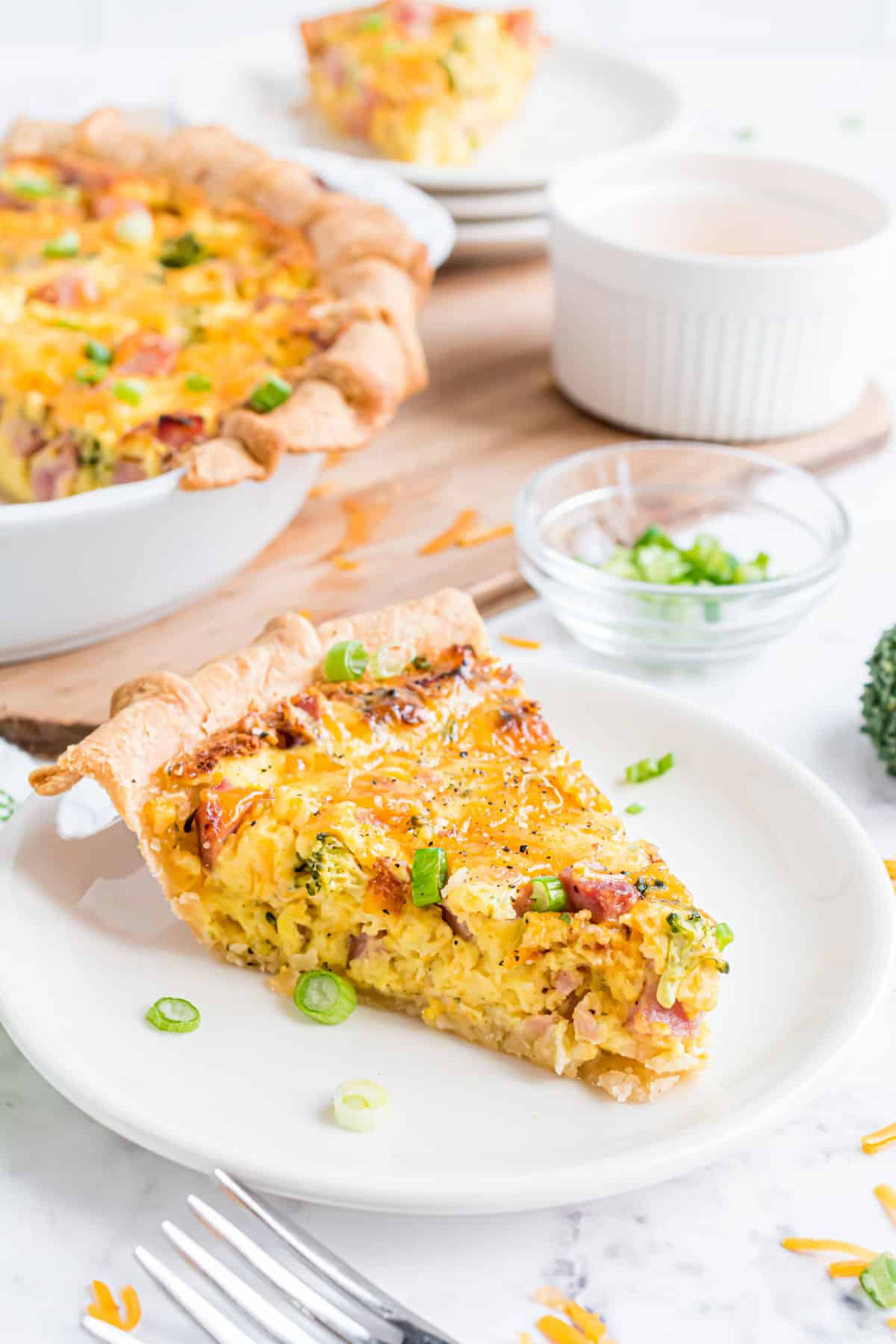 Quiche cut into slices and served on white plates.