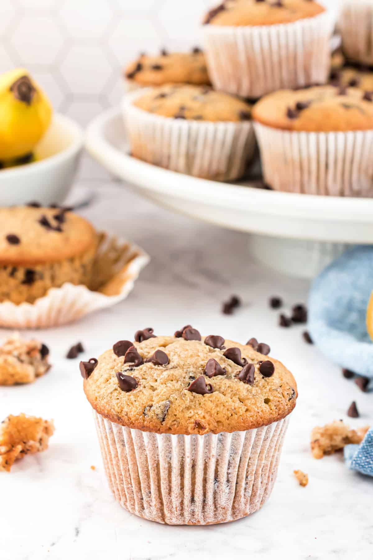Banana muffin with mini chocolate chips on counter.