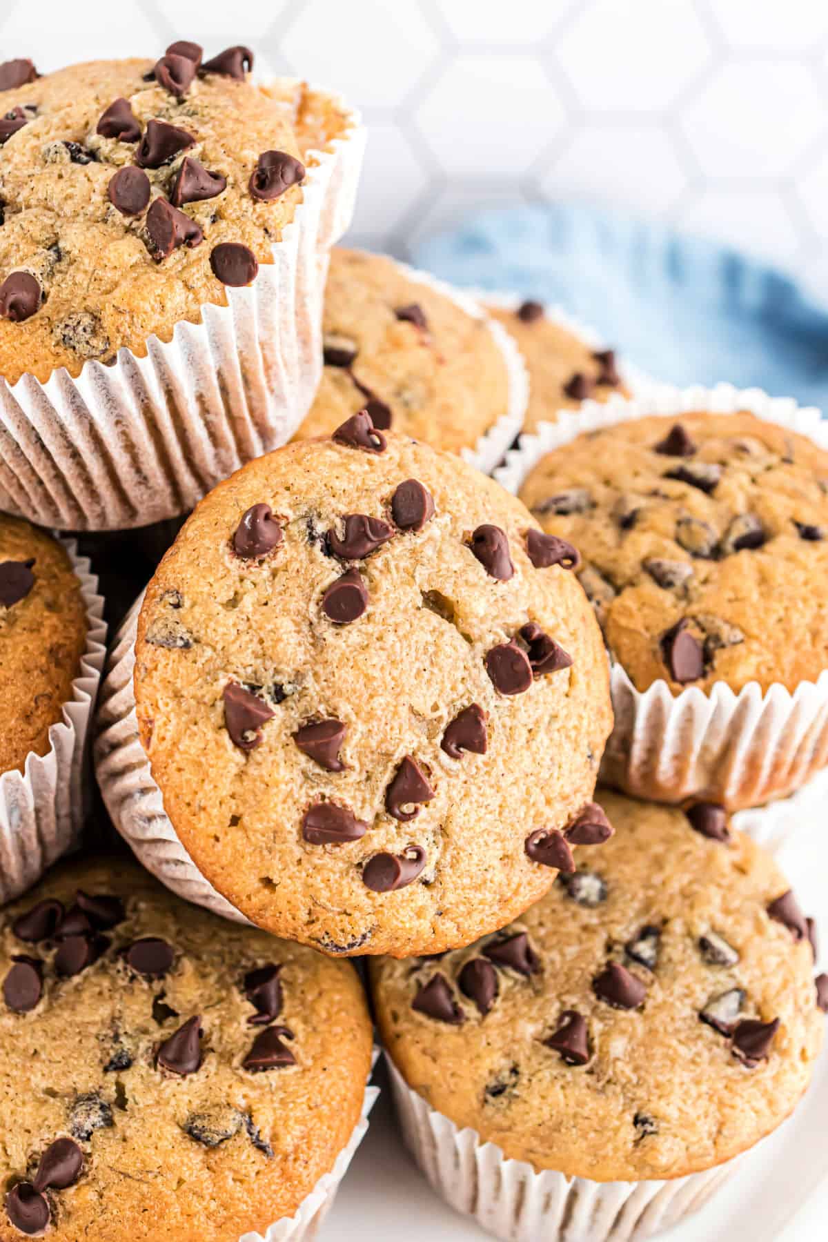 Stack of chocolate chip banana muffins on cake plate.